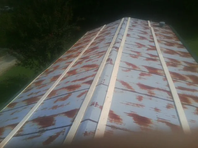 Rusted metal roof panels with new wood purlins before replacement — Storm Damage Roof Repair in Barnes City by Roofing Brothers