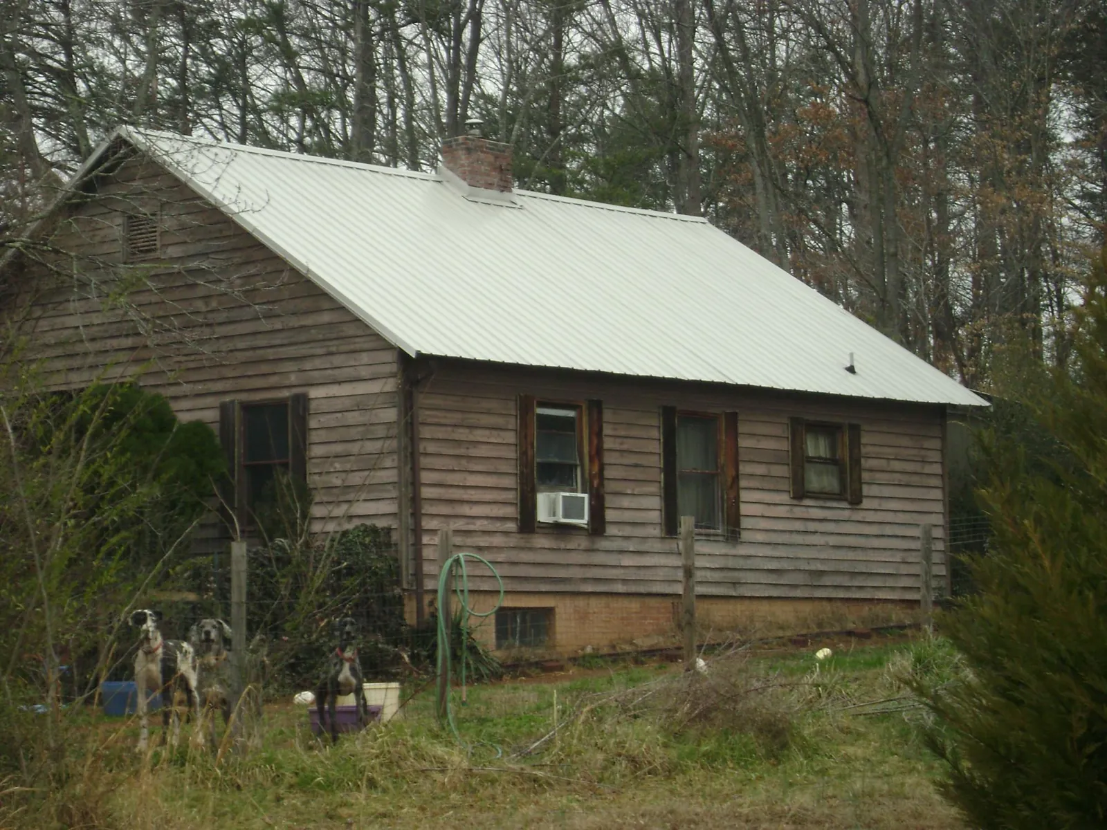 White metal roof on an old wood sided farmhouse, from a Metal Roof Installation job in Barnes City